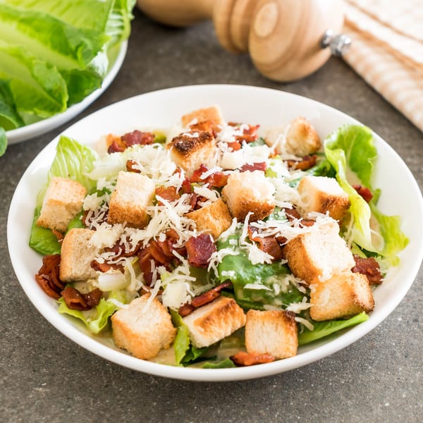 Caesar salad with crisp romaine lettuce, crunchy croutons, bacon bits, and shredded Parmesan cheese.